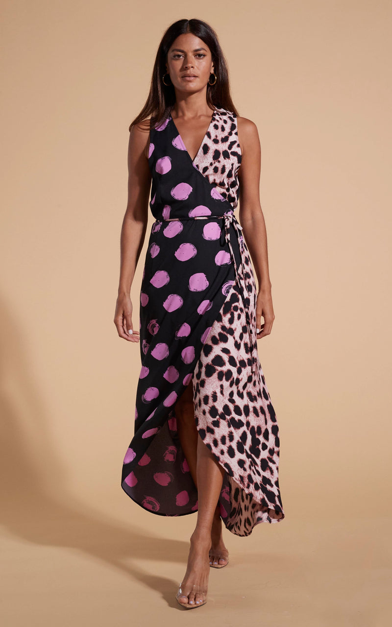 Model stands facing forwards wearing polka dot and leopard print wrap dress with heels