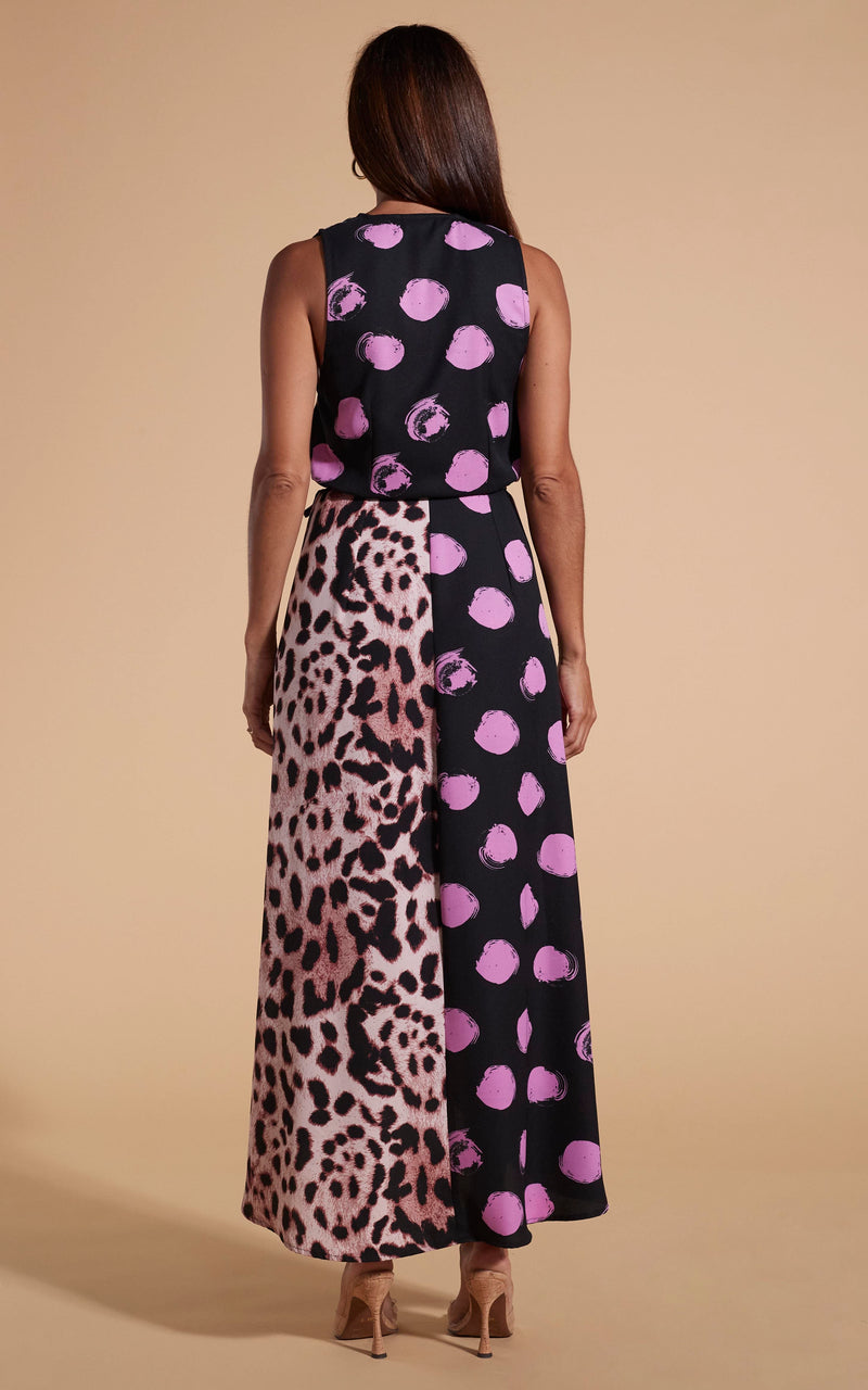 Model stands facing backwards wearing polka dot and leopard print wrap dress with heels