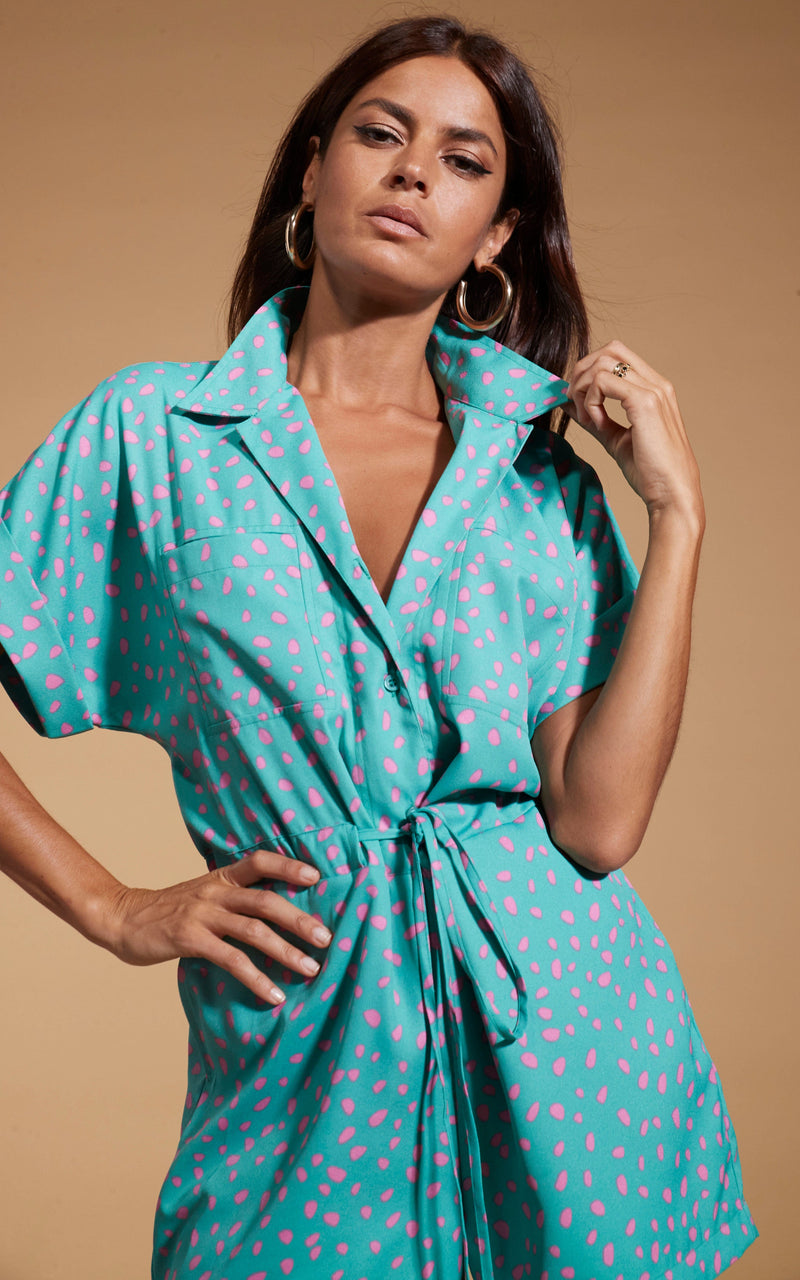 Dancing Leopard model wearing Rizzo Shirt Playsuit In Abstract Pink On Sea Green posed holding the collar