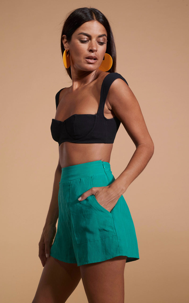 Dancing Leopard model wearing Lola Linen Shorts In Vivid Green stood side on with hand in pocket