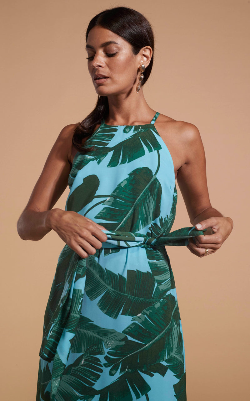 Dancing Leopard model wearing Sunset Dress In Vintage Blue Palm holding the tie of the dress