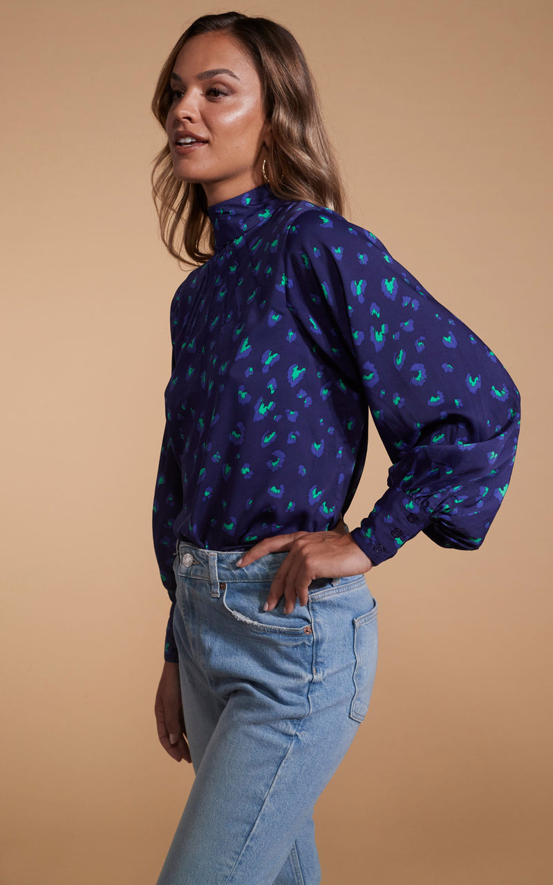 Dancing Leopard model wearing Margo Pintuck Blouse in Abstract Purple on Navy facing side on