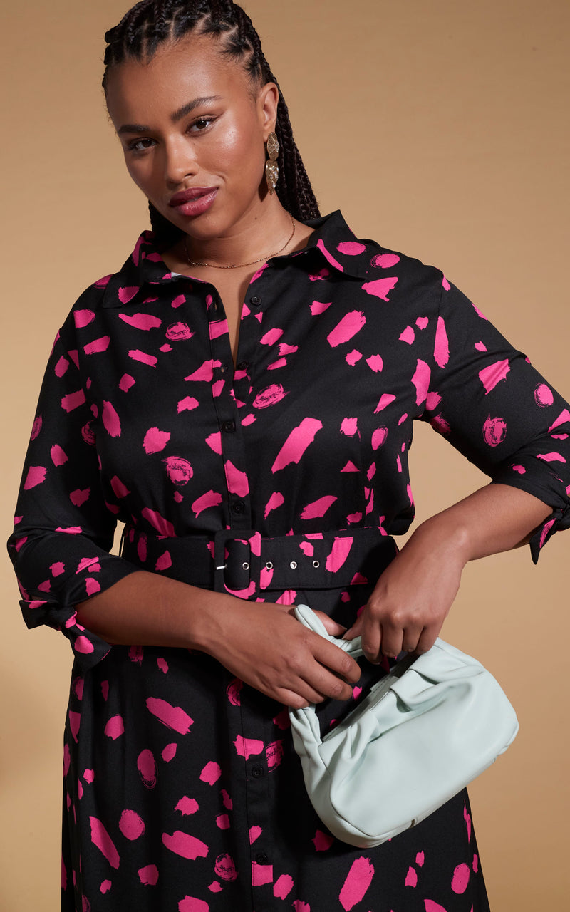 Model faces forward wearing a pink and black Dancing Leopard dress with a white bag.