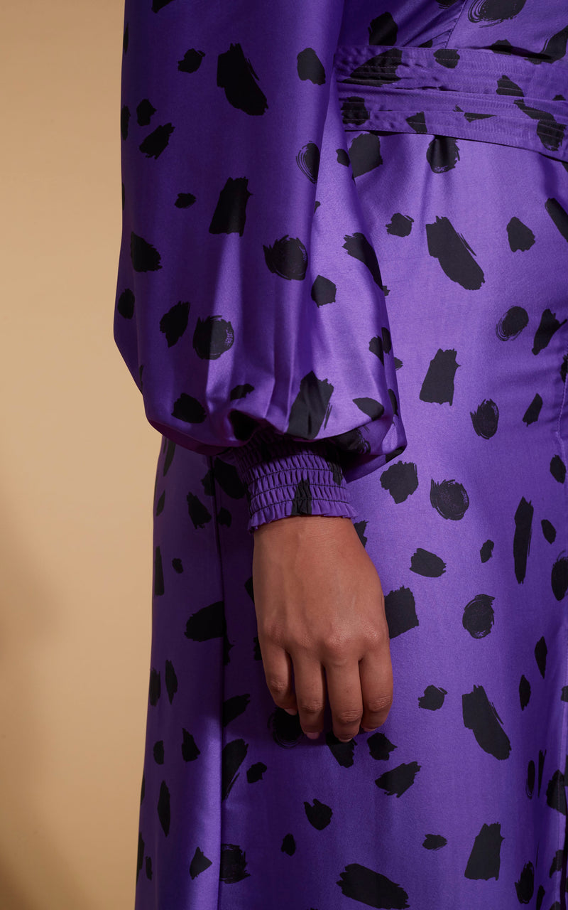 Model facing to the side wearing an abstract purple Dancing Leopard dress.