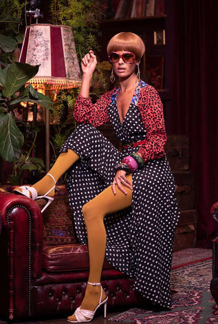 Dancing Leopard model wearing spotted dress sat on top of leather sofa