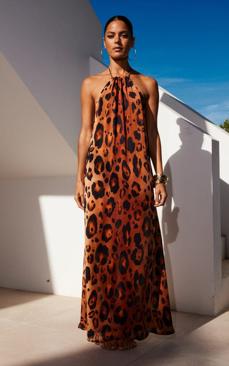 A female model faces forward. She wears a Dancing Leopard leopard print maxi dress.