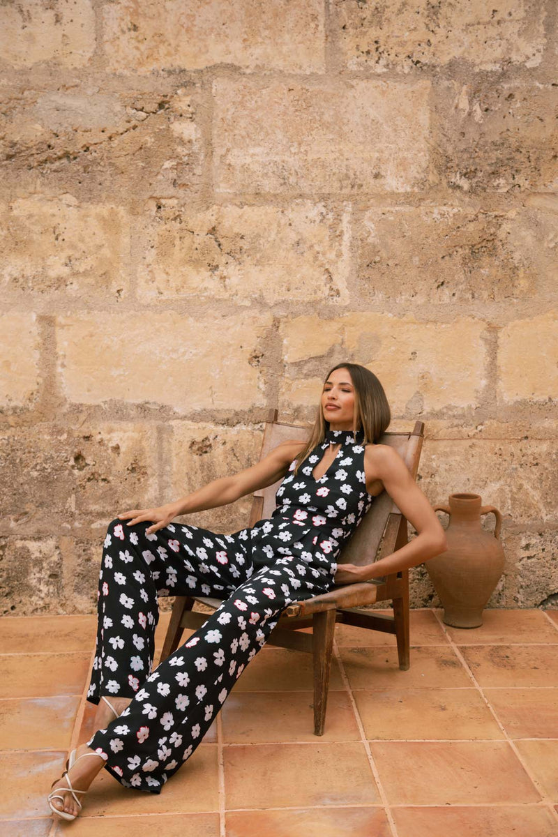 Dancing Leopard model sat in lounger chair wearing Cypress Jumpsuit in Mono Daisy