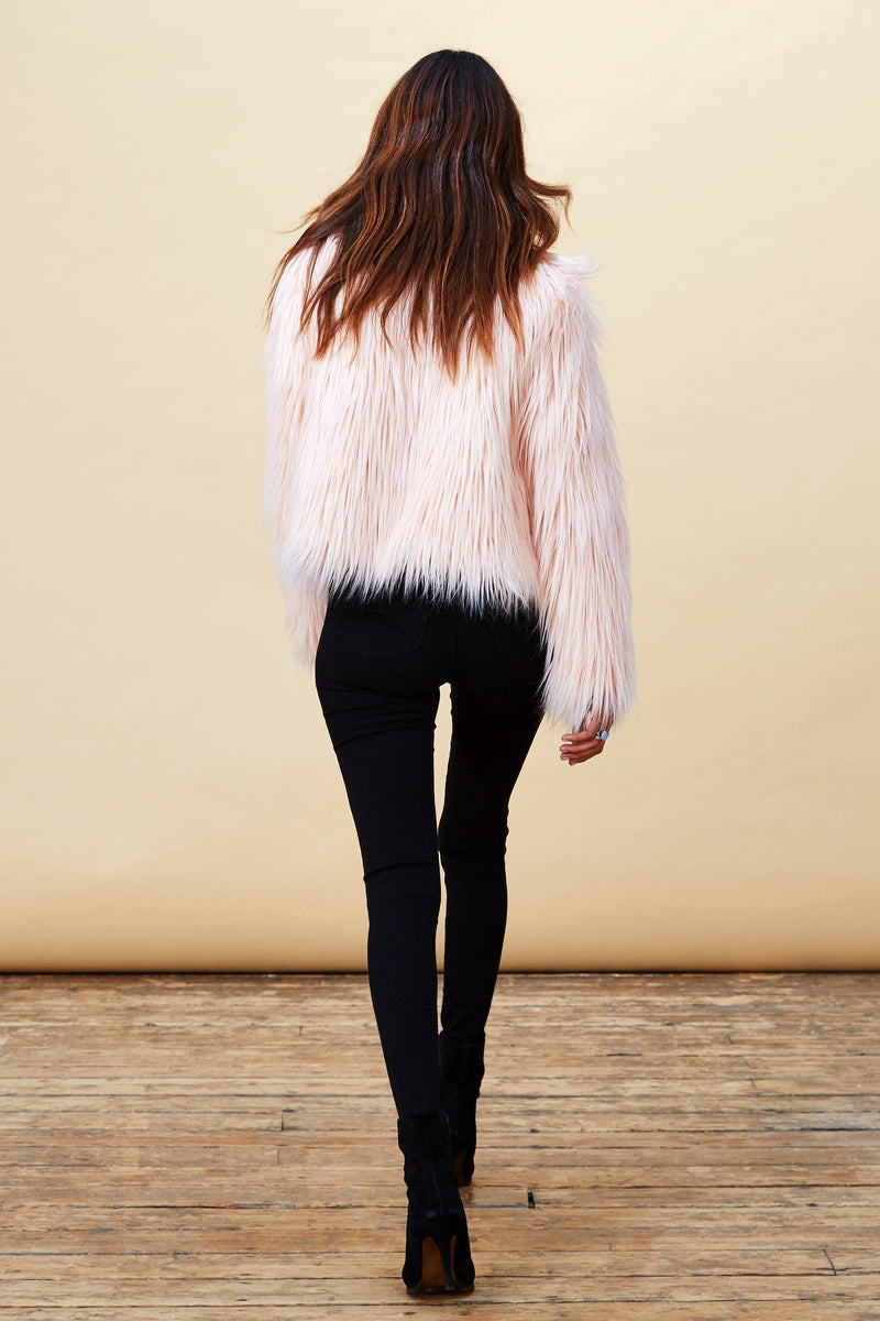 Model facing backwards wearing a pink Dancing Leopard faux fur jacket.