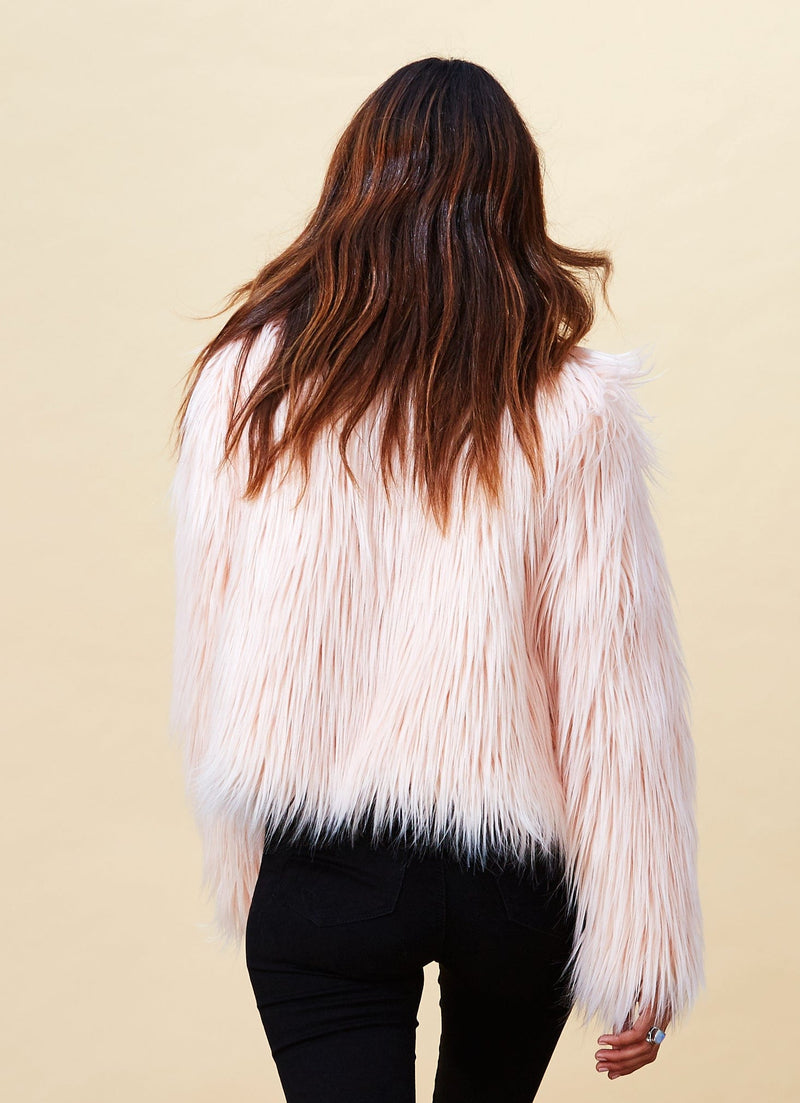 Model facing backwards wearing a pink Dancing Leopard faux fur jacket.