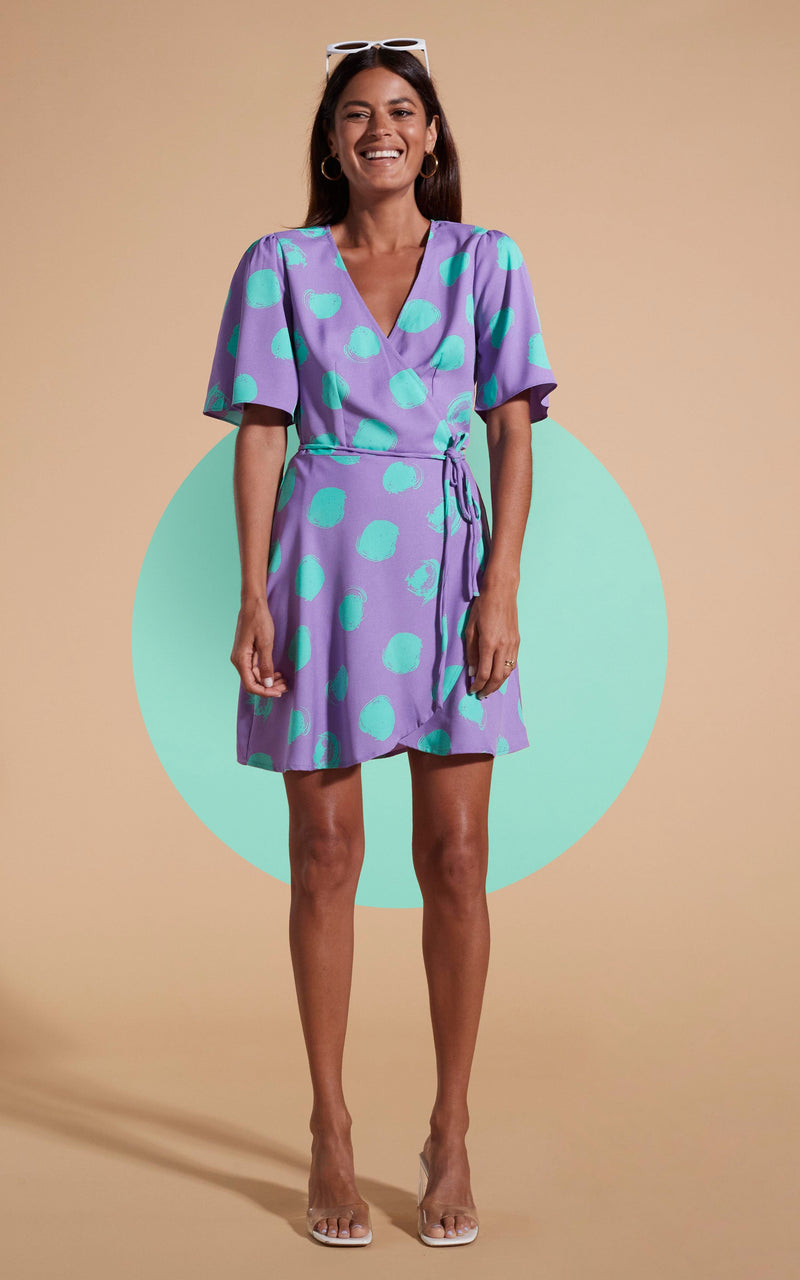 Dancing Leopard model wearing Rafferty Dress In Green On Purple Dot posed laughing