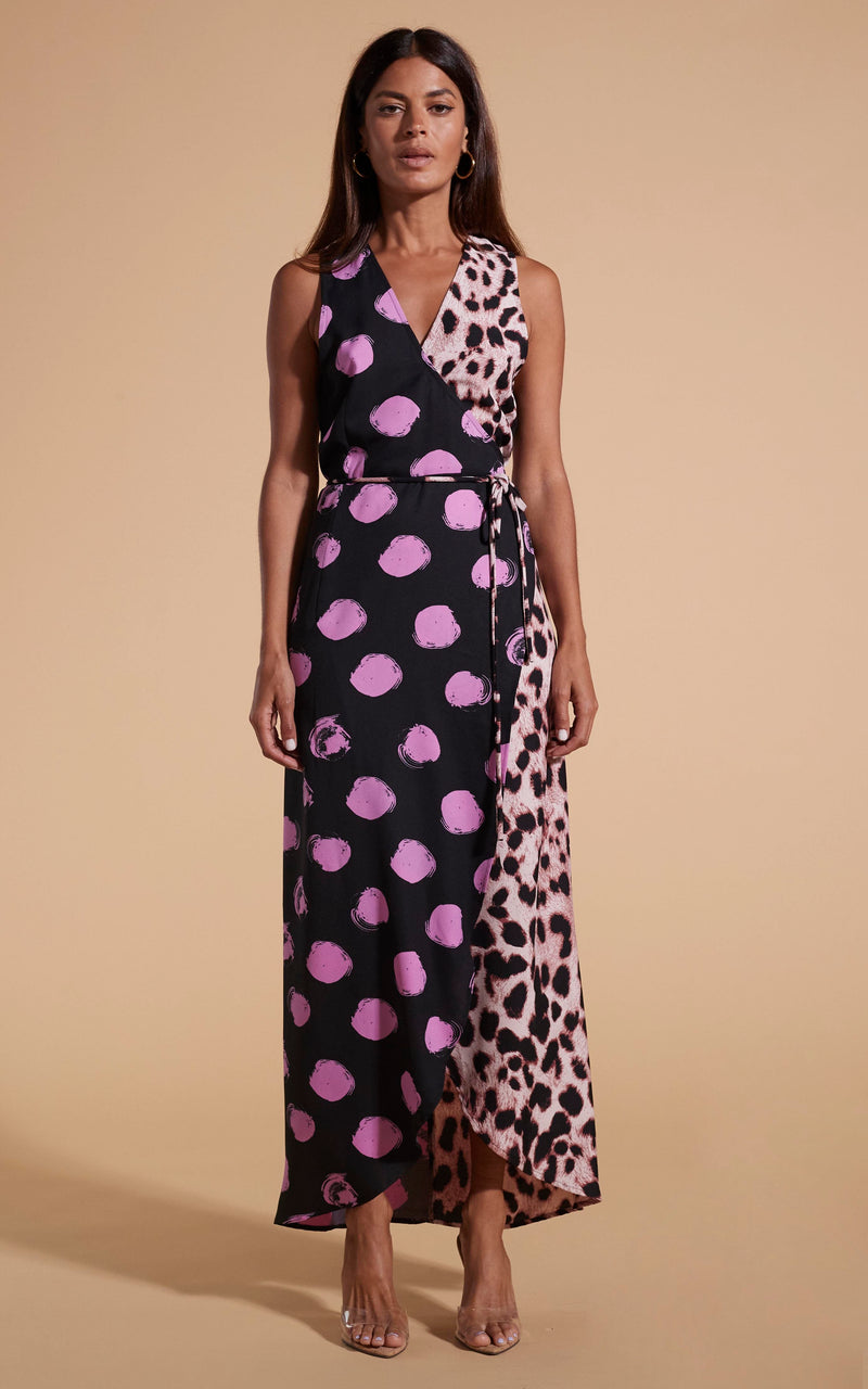 Model stands facing forwards wearing polka dot and leopard print wrap dress with heels