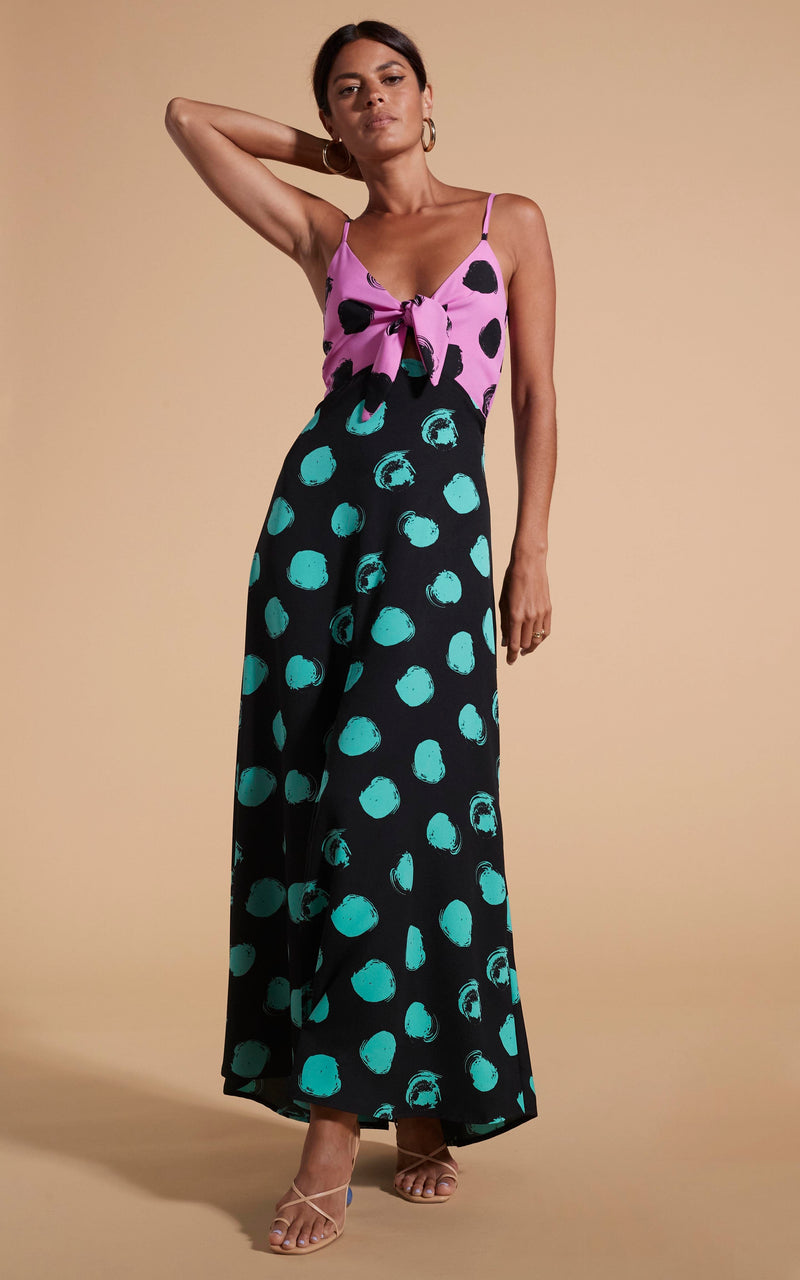 Dancing Leopard model wearing Florence Dress In Black On Pink Dot & Green On Black Dot posed with hand on hair