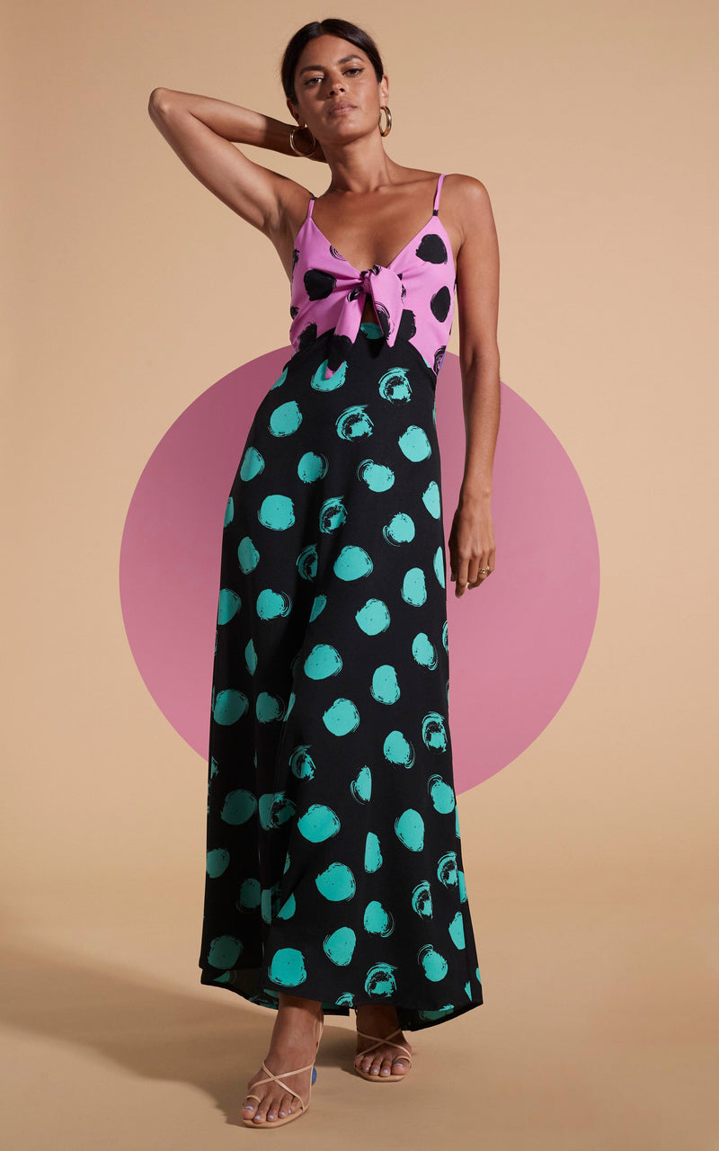 Dancing Leopard model wearing Florence Dress In Black On Pink Dot & Green On Black Dot posed with hand on hair