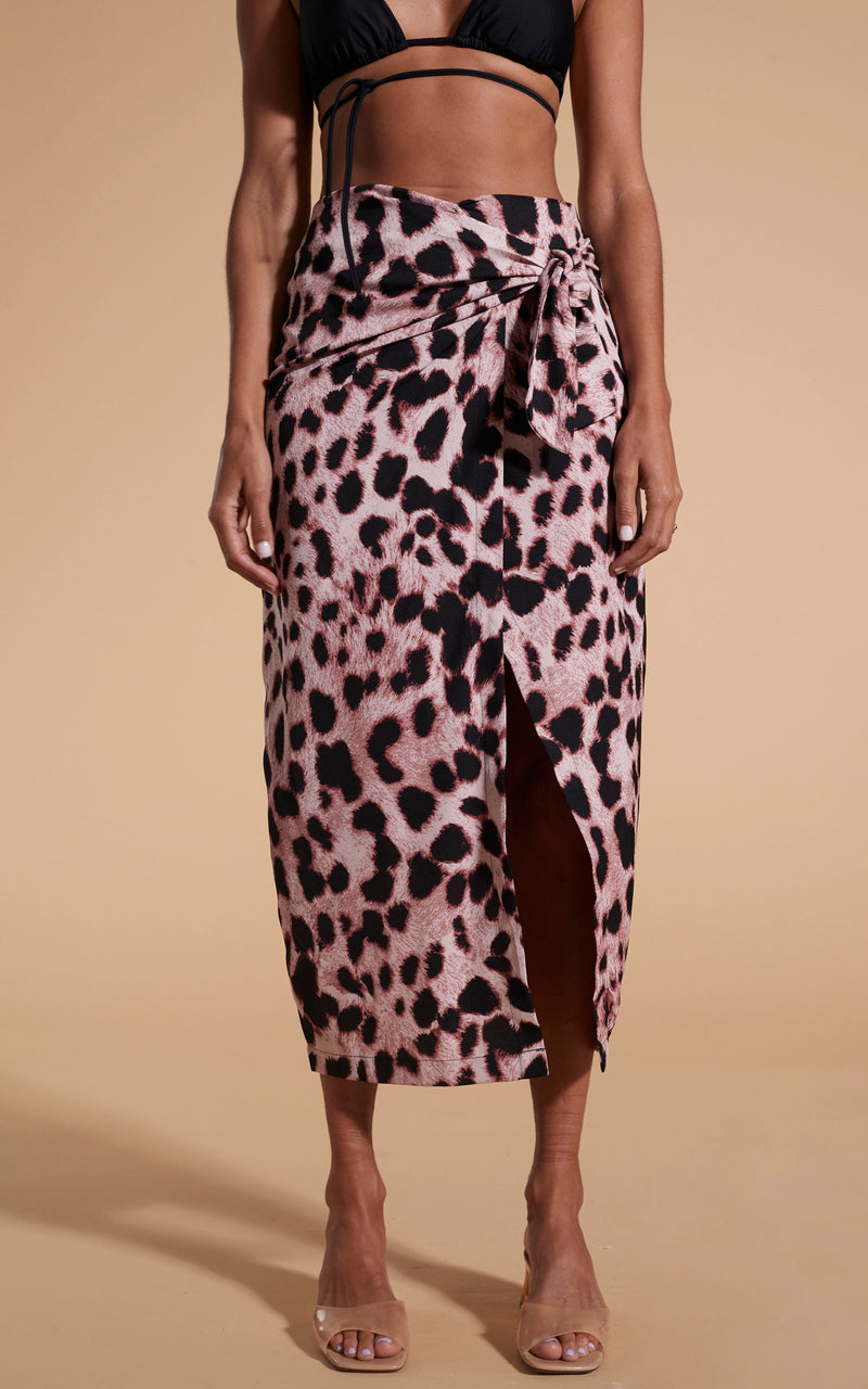 Model stands facing forwards wearing leopard print skirt and black bikini top