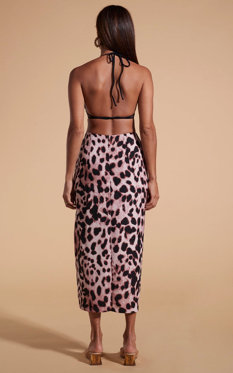 Model stands facing backwards wearing leopard print skirt and black bikini top