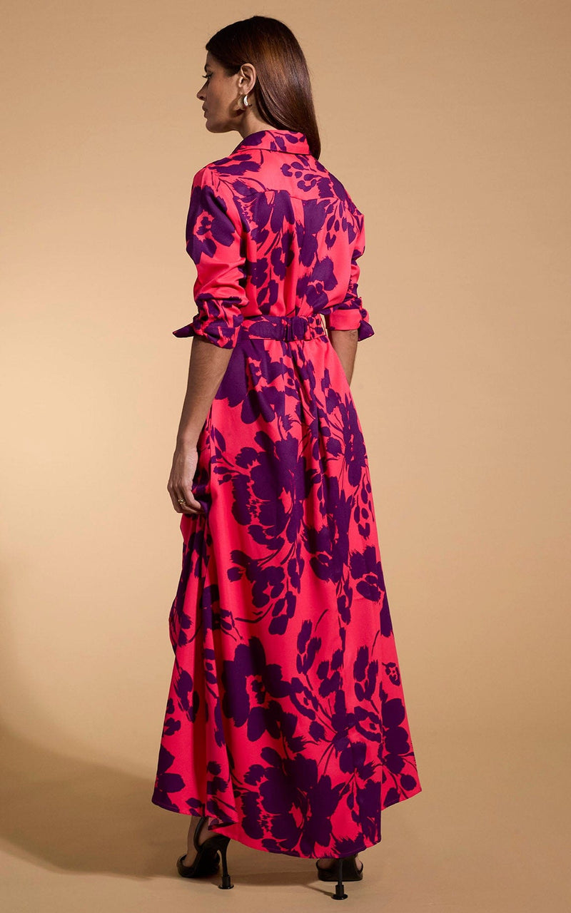 A female model faces backwards. She wears a Dancing Leopard maxi shirt dress. The dress is red with a plum coloured flower print.