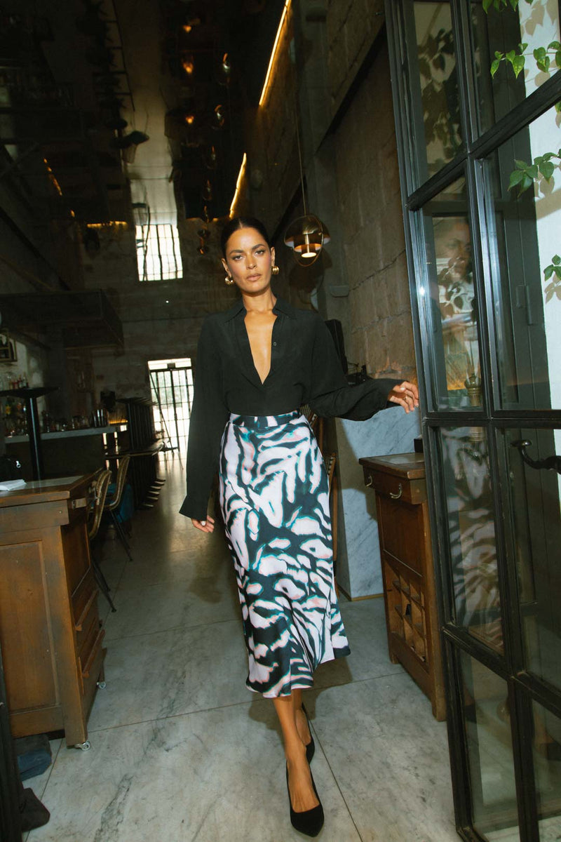 Model faces forward wearing a  zebra print Dancing Leopard skirt with a black shirt.