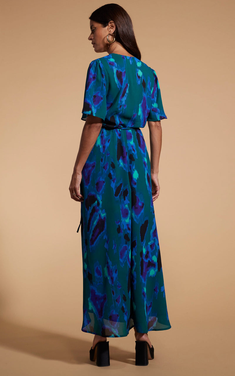 Model faces backwards wearing a camo blue/green Dancing Leopard Dress.