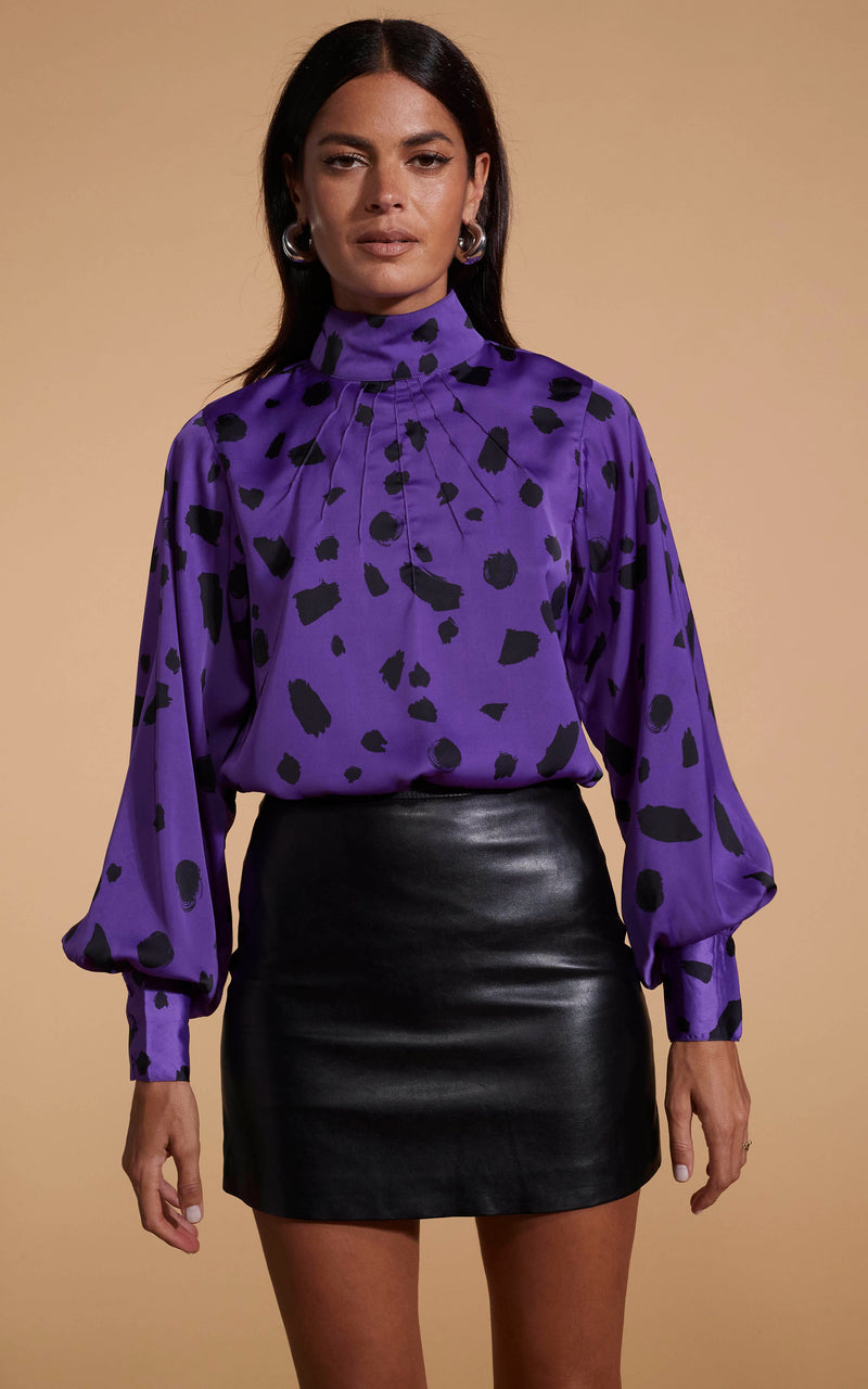 Model faces forward wearing a long sleeve purple high neck Dancing Leopard top with an abstract print.