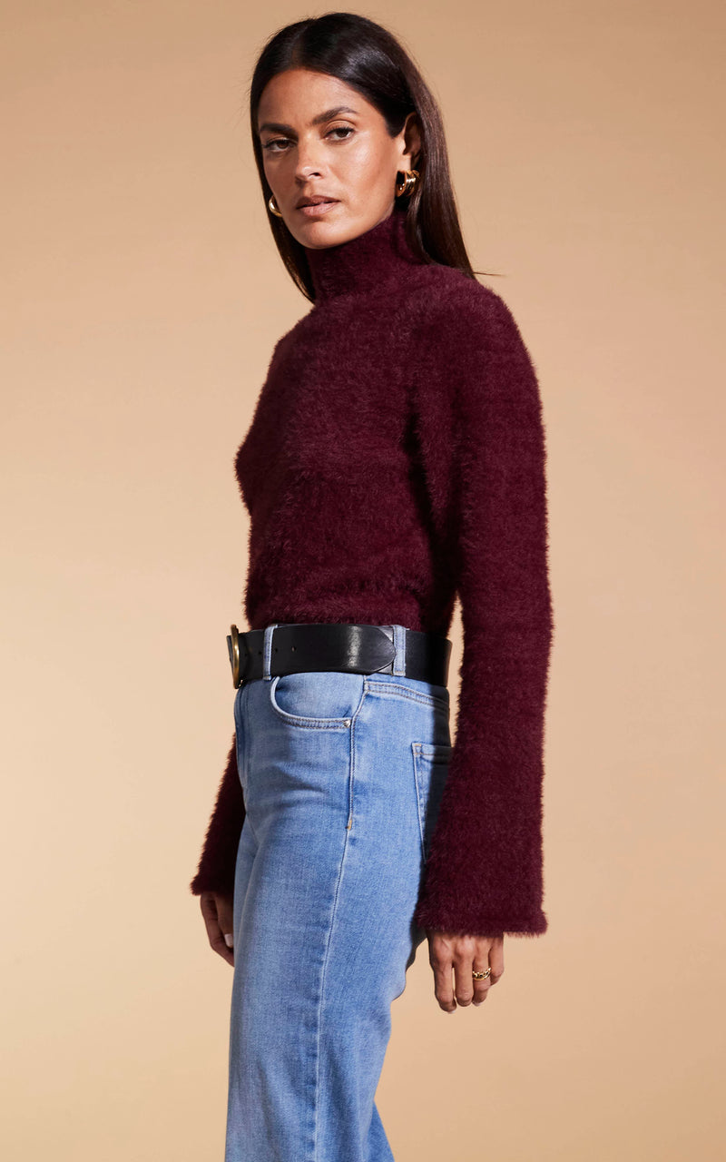 Model faces side-on wearing Dancing Leopard burgunday knitted jumper