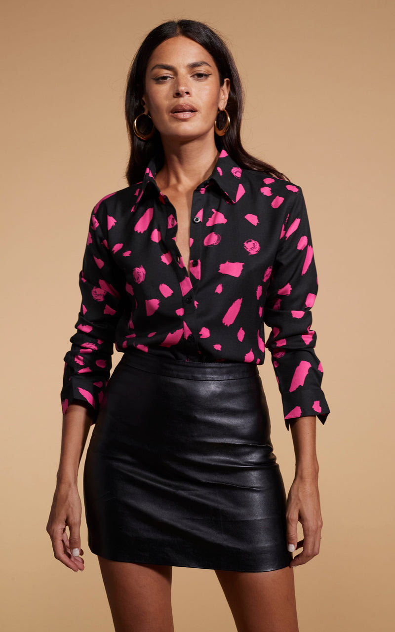 Model faces forward wearing a black and pink Dancing Leopard shirt with a black skirt.