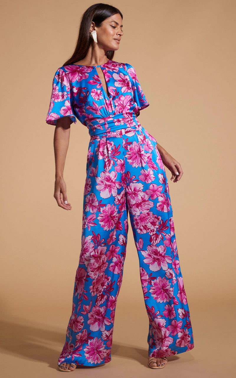 Dancing Leopard model wearing Savannah Jumpsuit In Pink On Blue Floral looking to the side