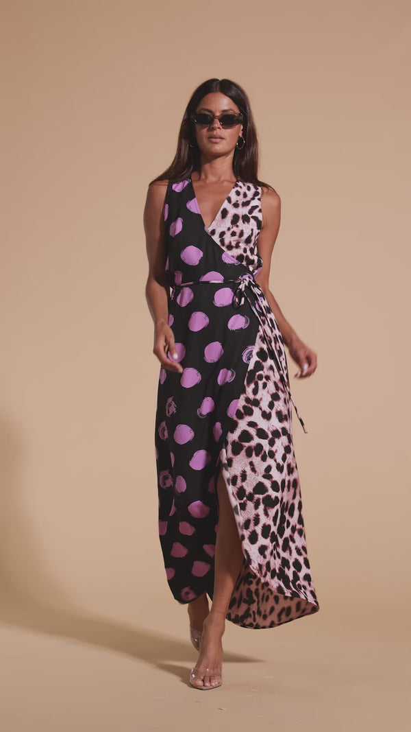 Model walks forwards wearing polka dot and leopard print wrap dress with heels