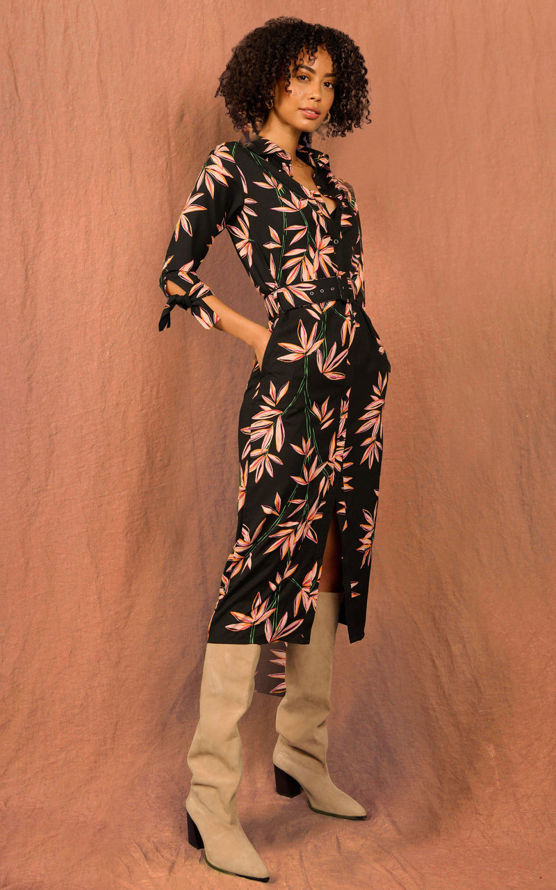 Dancing Leopard model standing with hands in pockets  wearing a midi shirt dove dress in bamboo on black print and tan knee high boots