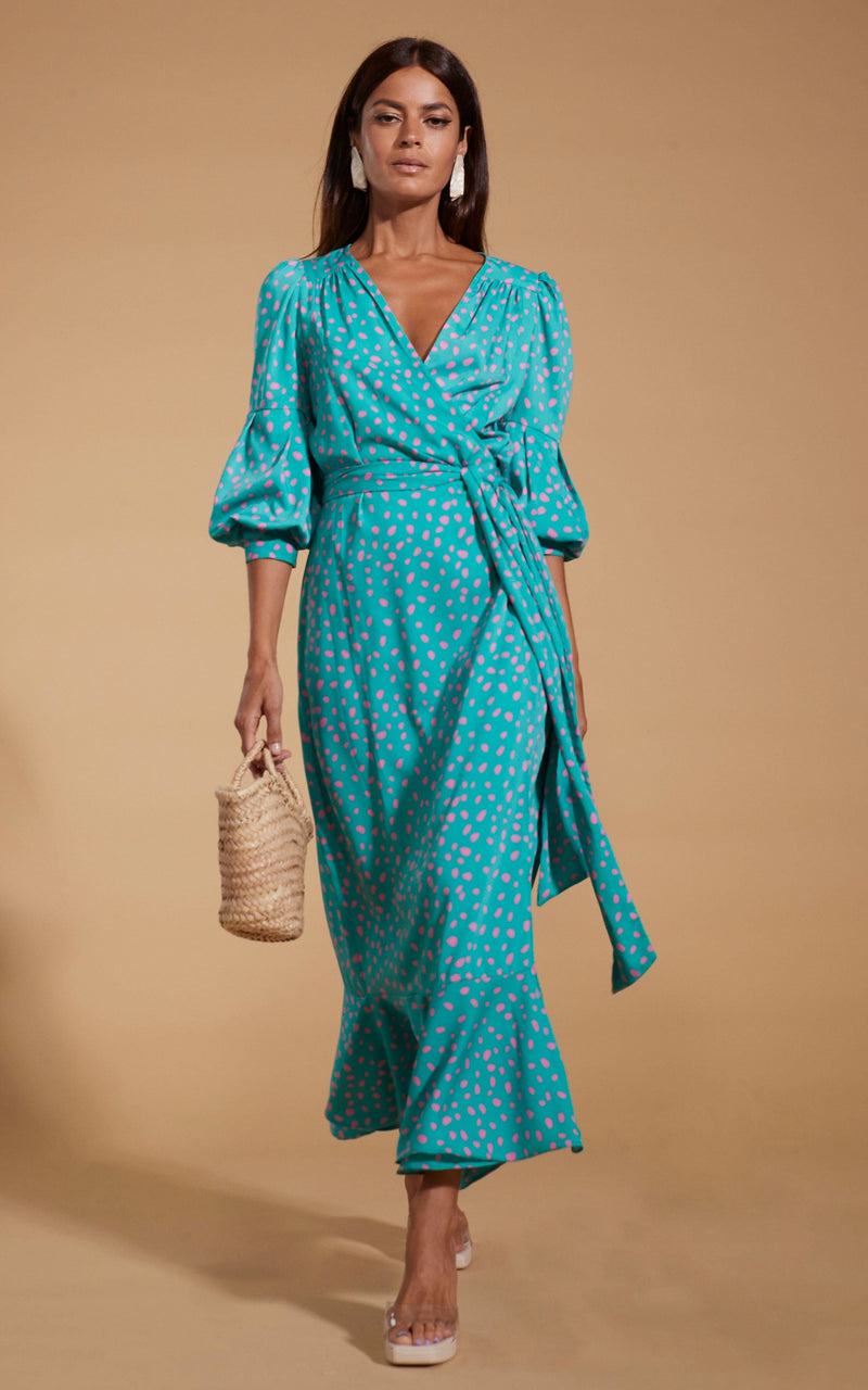 Dancing Leopard model wearing Havannah Maxi Wrap Dress in Abstract Pink on Sea Green walking towards shot