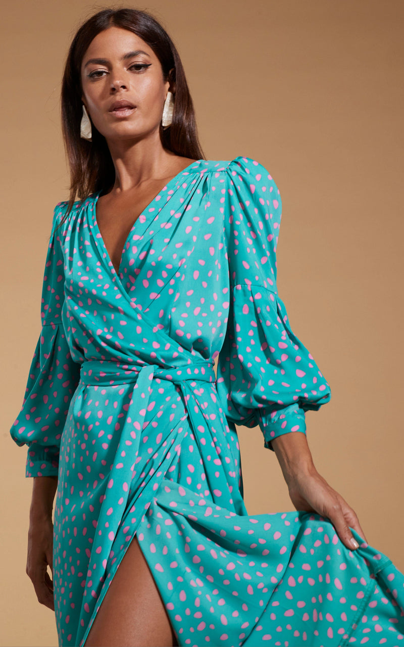 close up of Dancing Leopard model wearing Havannah Maxi Wrap Dress in Abstract Pink on Sea Green posed holding the dress out
