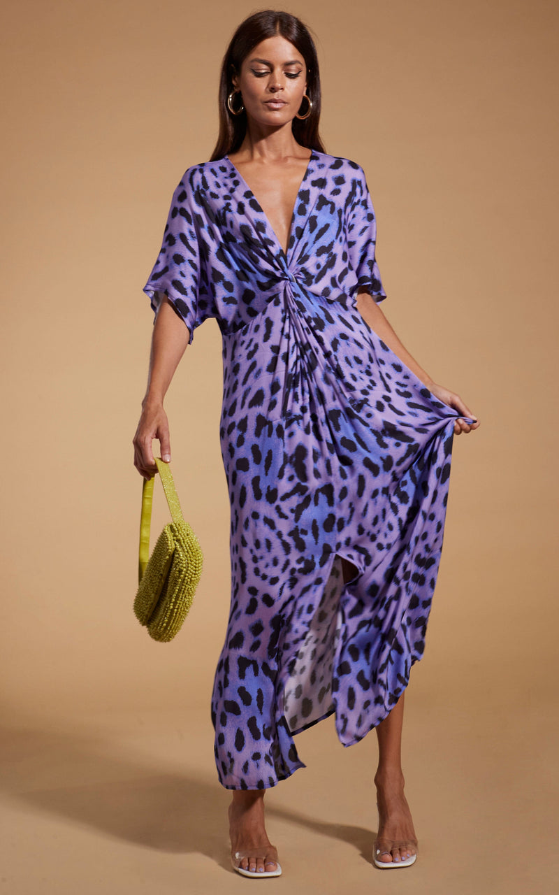 Dancing Leopard model wearing Makuna Kaftan In Lilac Leopard and holding handbag