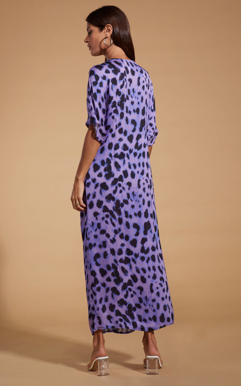 Dancing Leopard model wearing Makuna Kaftan In Lilac Leopard facing away to show back of dress