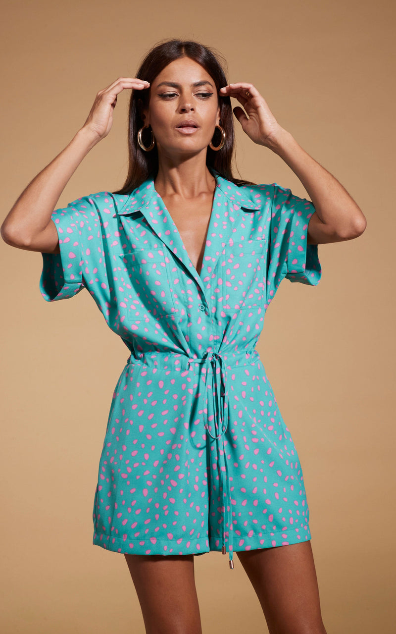 Dancing Leopard model wearing Rizzo Shirt Playsuit In Abstract Pink On Sea Green posed with hands on hair