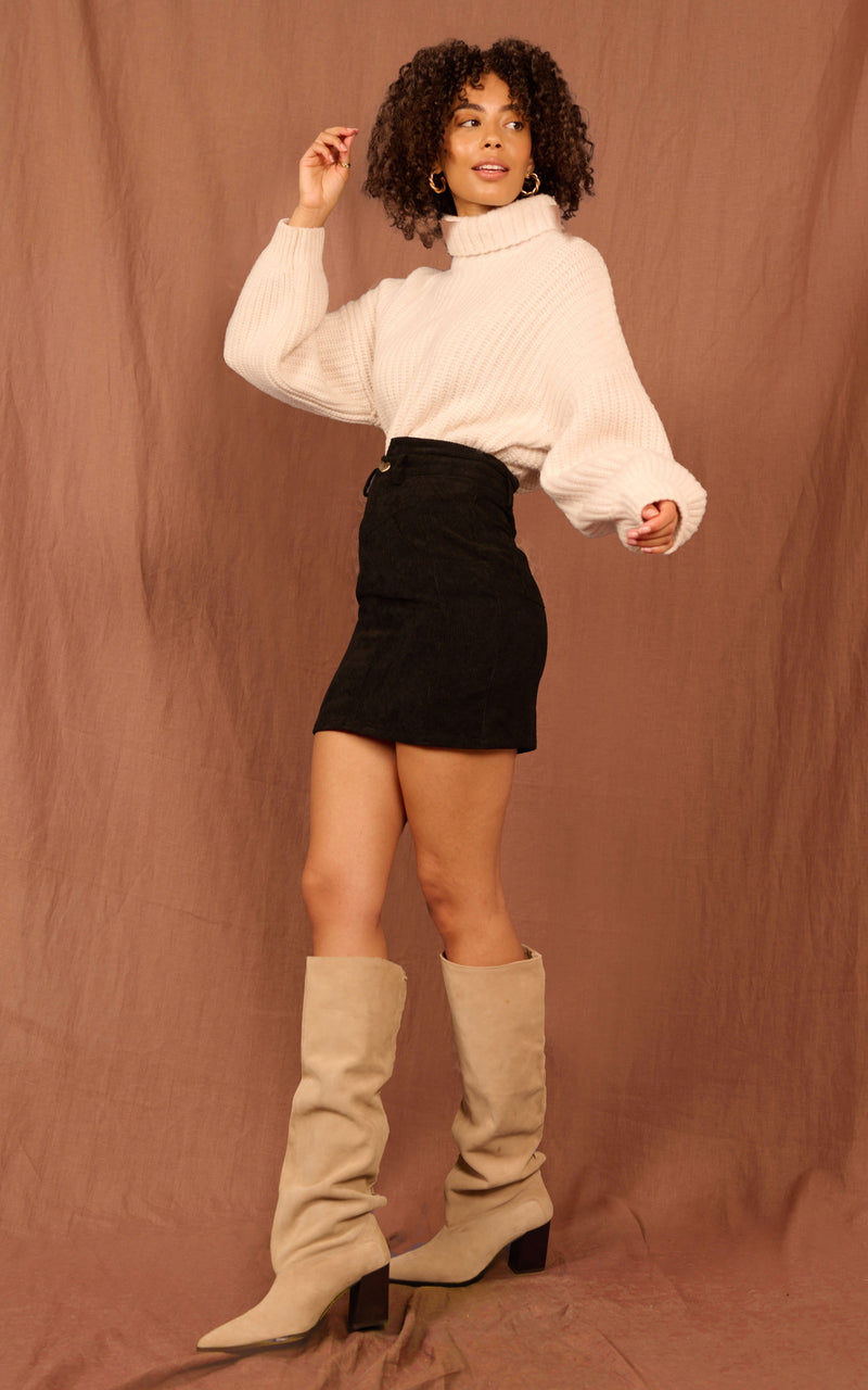 Dancing Leopard model wearing black Nikeeta skirt with cream jumper and tan knee high boots