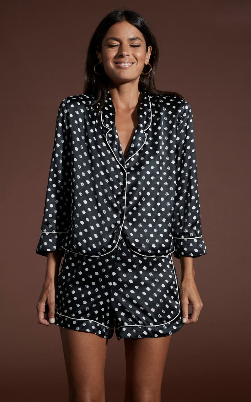 Dancing Leopard model wearing Oona Shortie PJ Set in Black Polka Dot posed with eyes closed and hands by side
