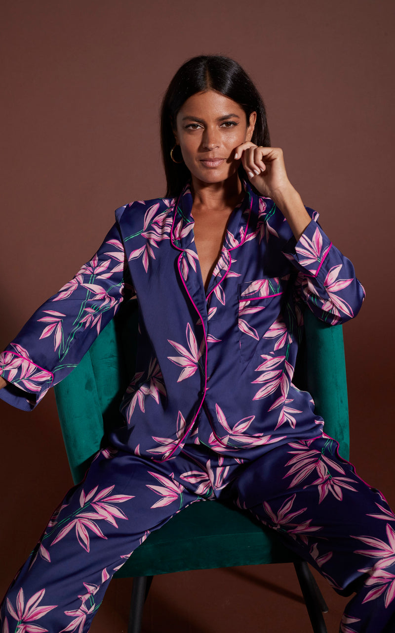 Dancing Leopard model wearing Cosmos Satin Long Leg PJ Set in Bamboo Navy Base sat on green chair