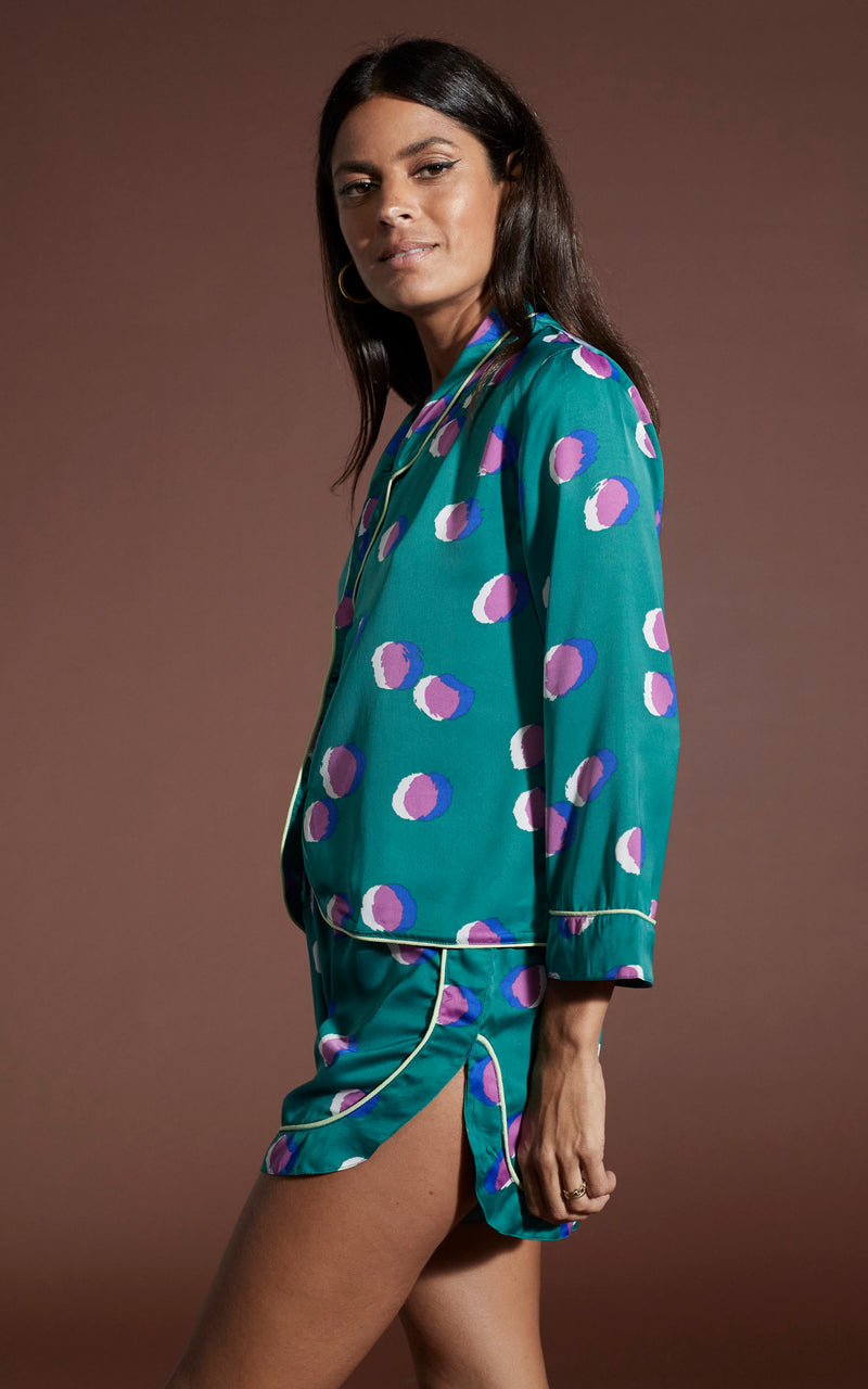 Dancing Leopard model wearing Oona Shortie PJ Set in Polka Dot Purple on Green posed side on