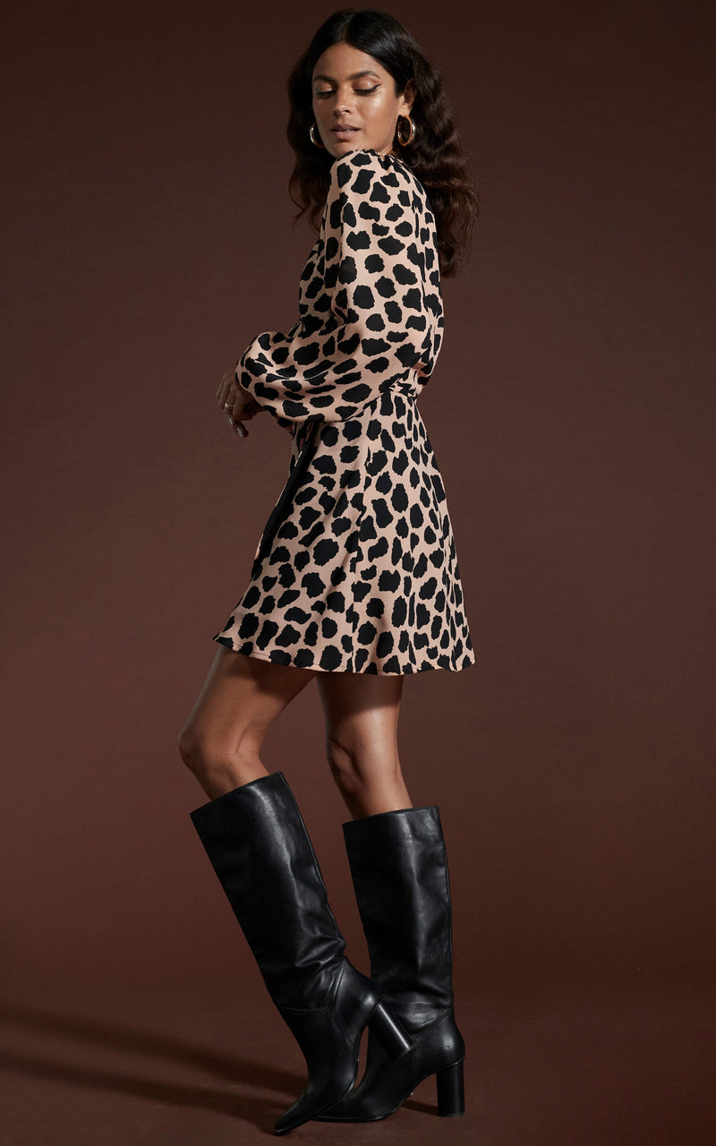 Dancing Leopard model wearing Ginger Mini Wrap Dress In Beige Cloud facing side on looking over shoulder