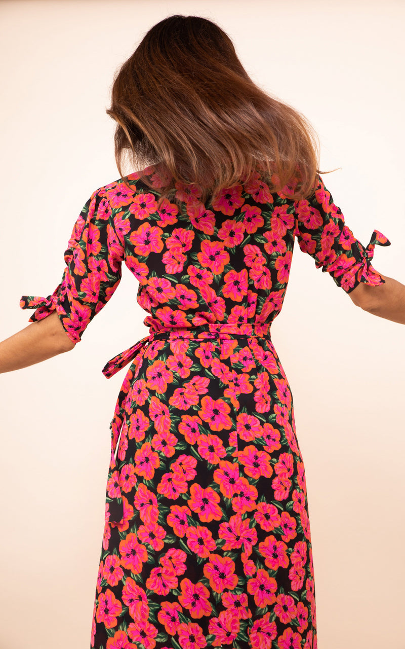 Dancing Leopard model faces backwards wearing Olivera Midi Dress in pink floral print