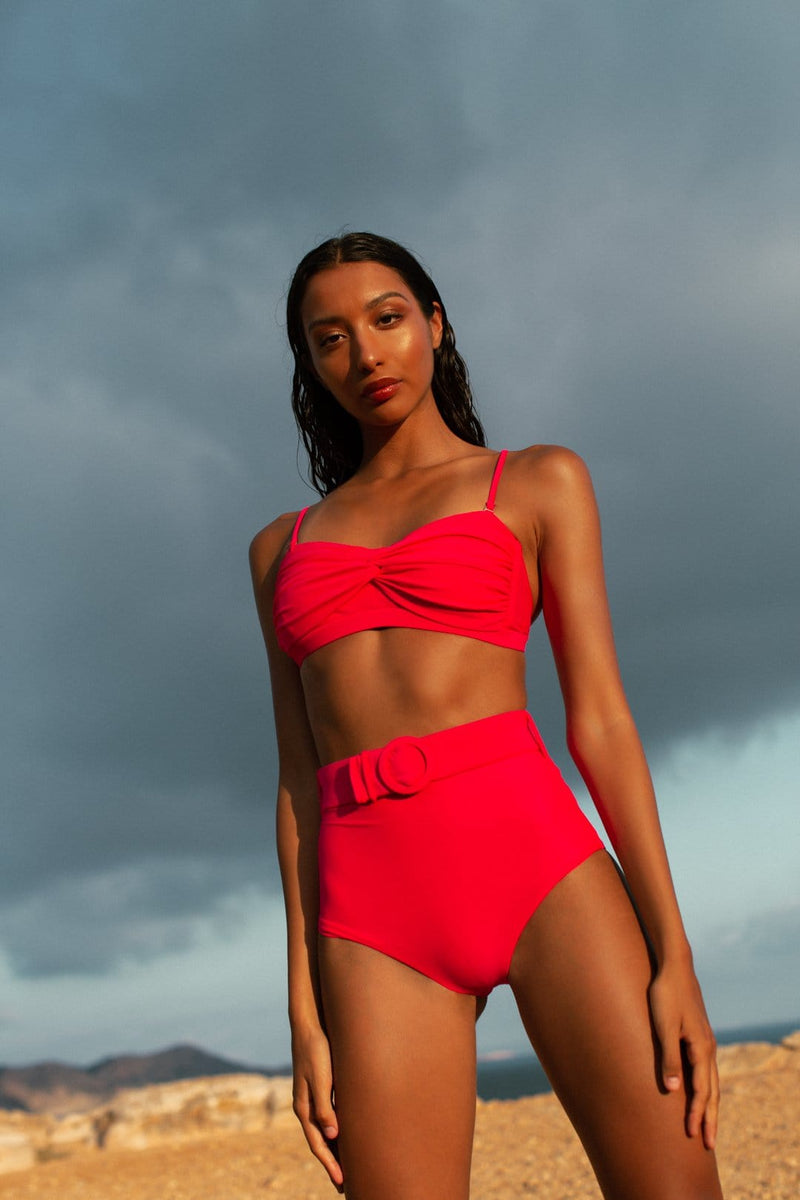 Dancing Leopard model faces forward and stands on beach wearing HALO Juniper bikini brief and Lalita bikini top in pink