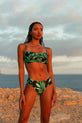 Dancing Leopard model faces backwards wearing tropical print bikini top and bottoms on beach