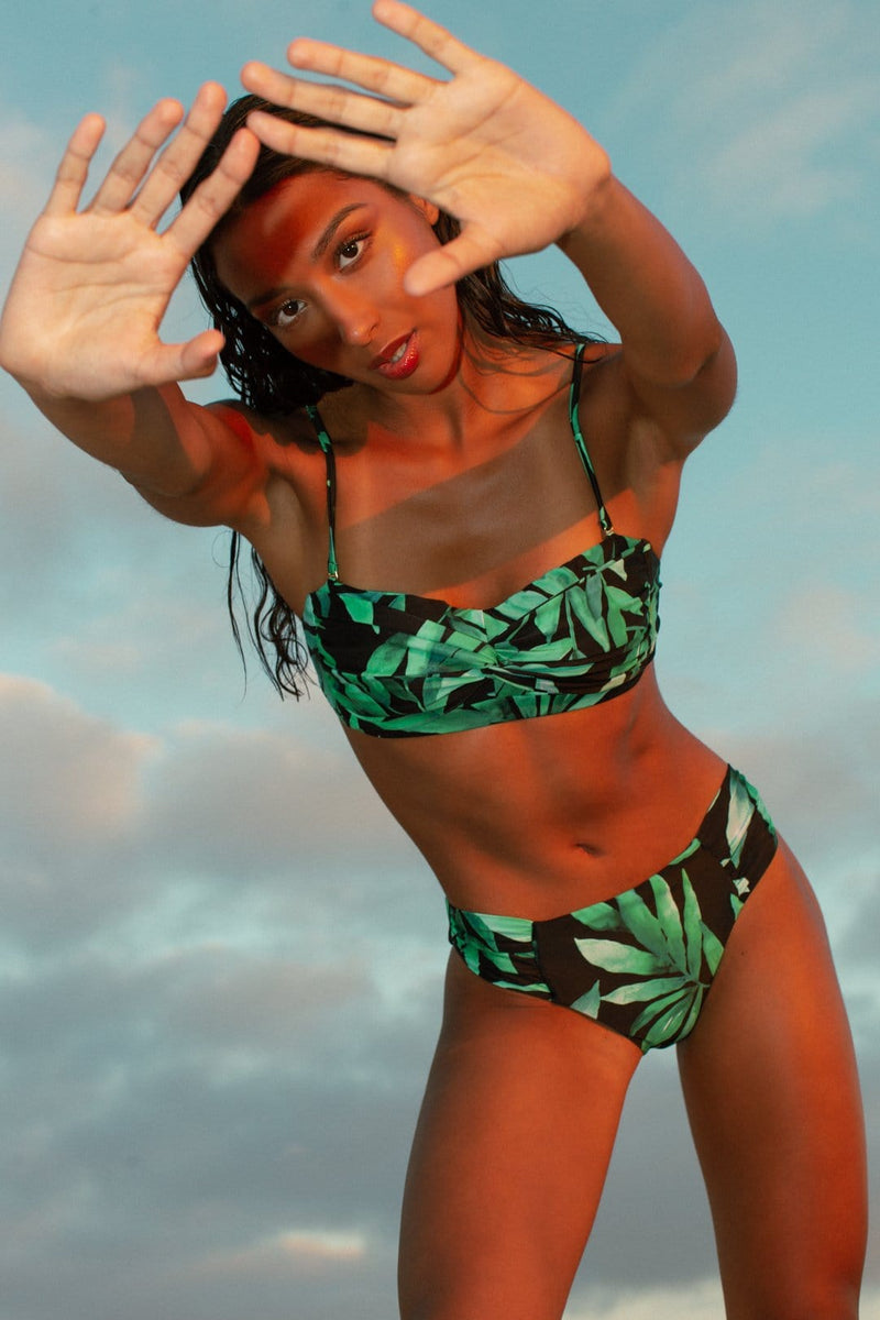 Dancing Leopard model faces forward wearing Lalita Bikini Top and bottoms in tropical print with blue sky background