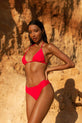Dancing Leopard model faces forwards with hands on hips wearing hot pink bikini on a beach