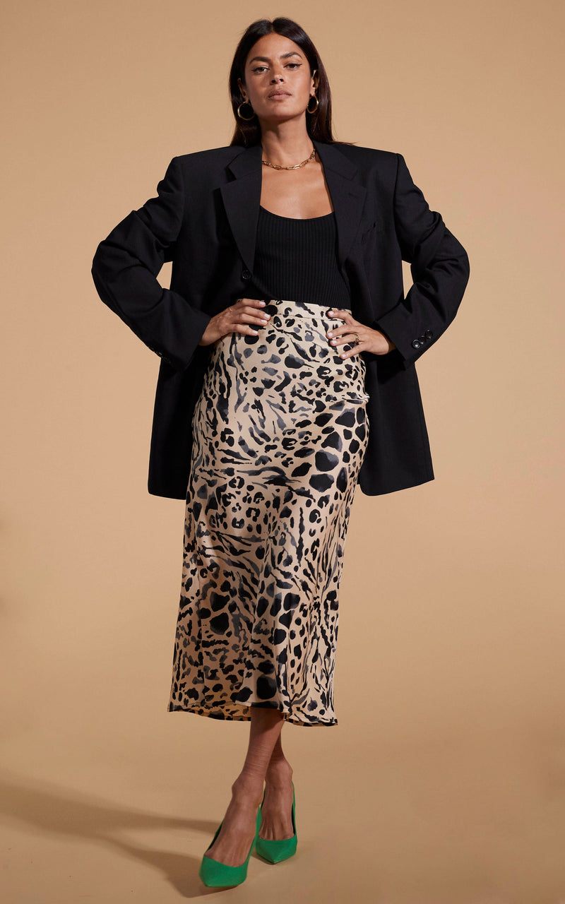 Dancing Leopard model wearing Renzo Skirt In Smudge Leopard with black top and blazer posed with hands on hips