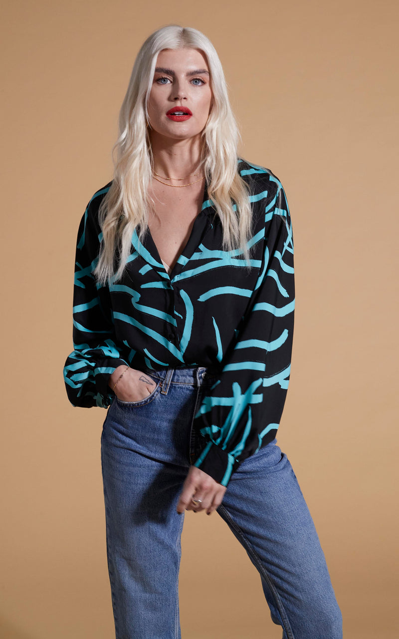 Dancing Leopard model wearing Dixie Balloon Sleeve Shirt In Blue Strokes On Black posed with hand in jeans pocket