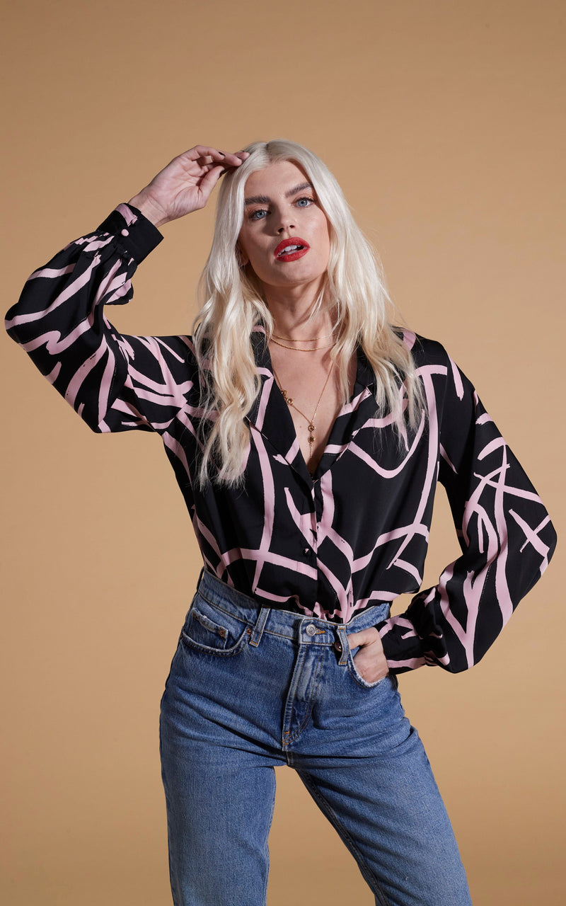 Dancing Leopard model wearing Dixie Balloon Sleeve Shirt In Pink Strokes On Black posed with hand on head
