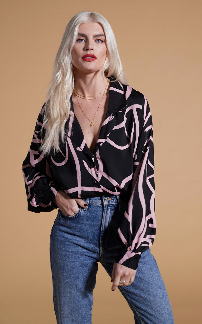 Dancing Leopard model wearing Dixie Balloon Sleeve Shirt In Pink Strokes On Black posed with hand in jeans pocket
