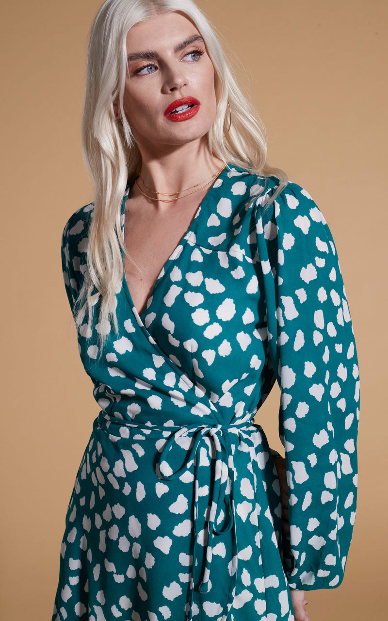 close up of Dancing Leopard model wearing Ginger Mini Wrap Dress In White On Green Cloud
