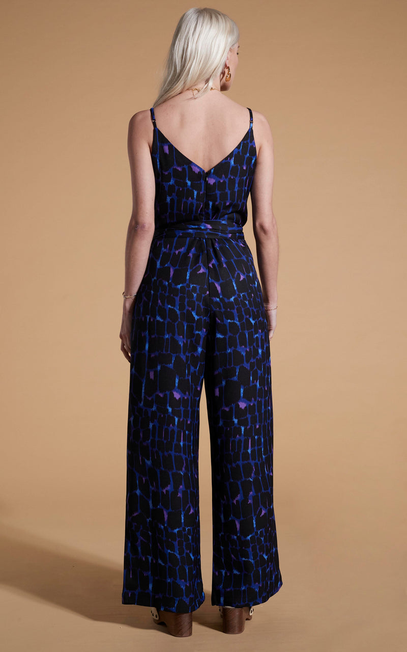 Dancing Leopard model wearing Gabriella Jumpsuit In Blue Alligator facing away to reveal back of garment