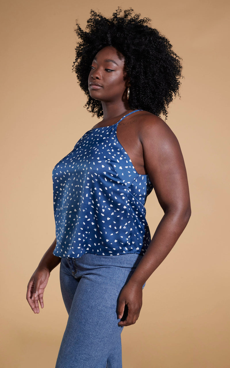 Dancing Leopard model standing sideaways wearing Nina halter cami top in abstract white on navy with denim blue jeans